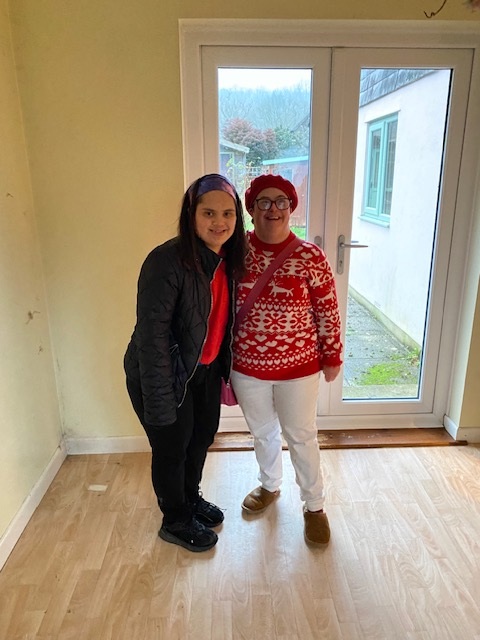 Two people standing in their house before it is decorated